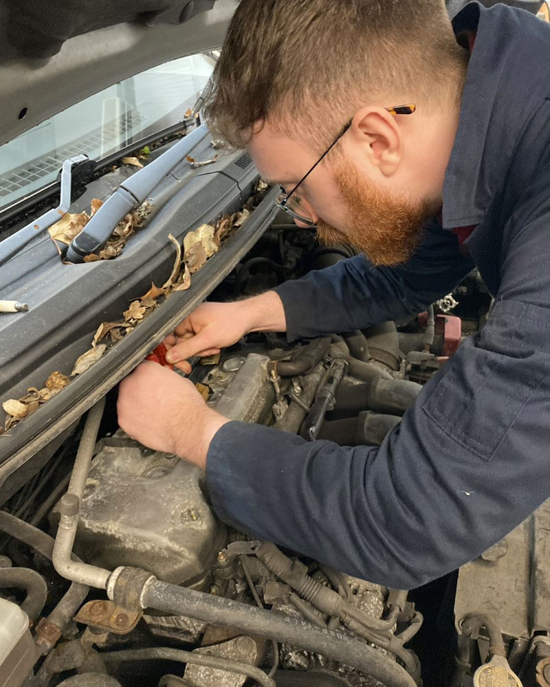 Young adult working on car engine
