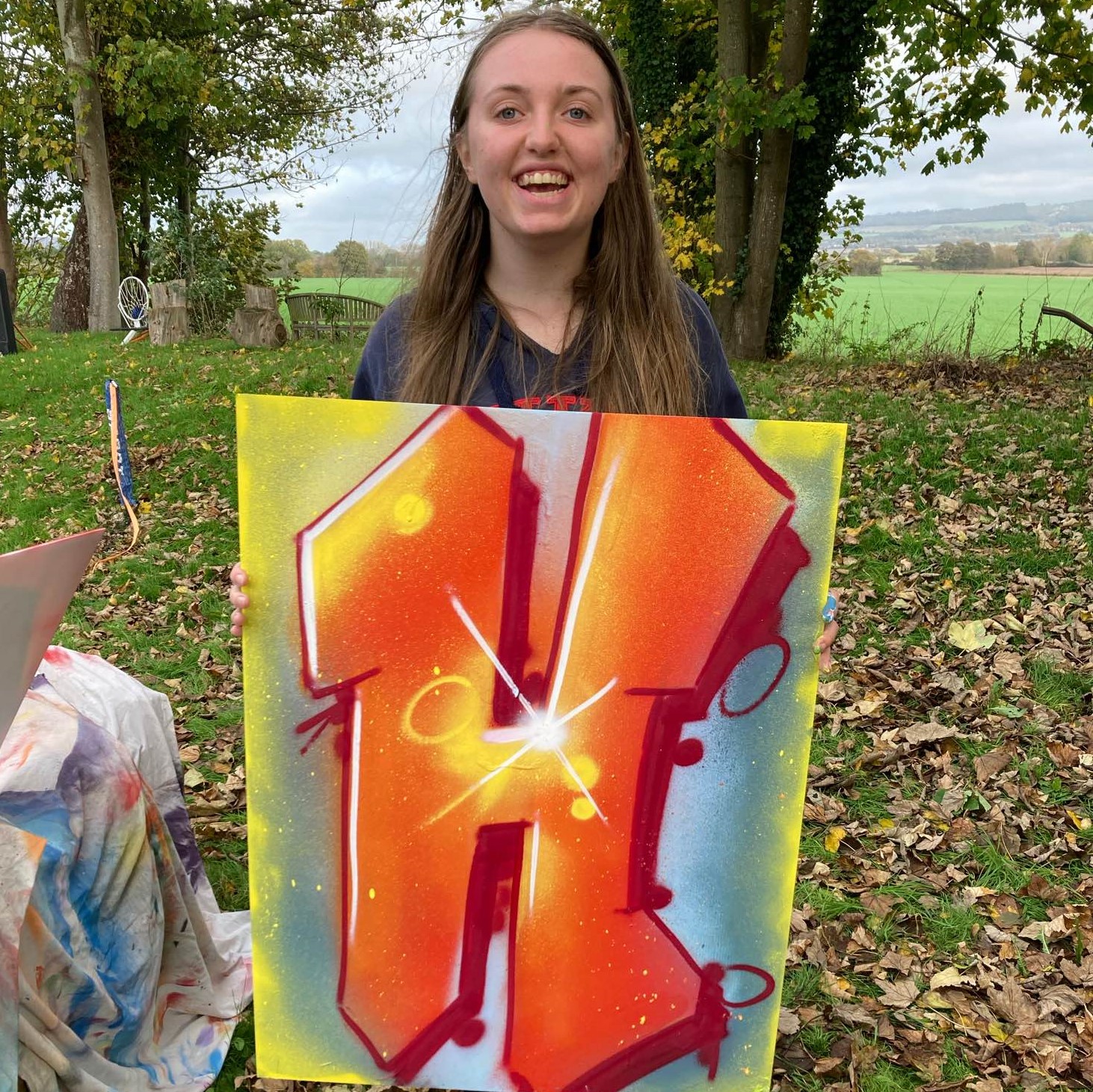 Young adult holding up graffiti art they created